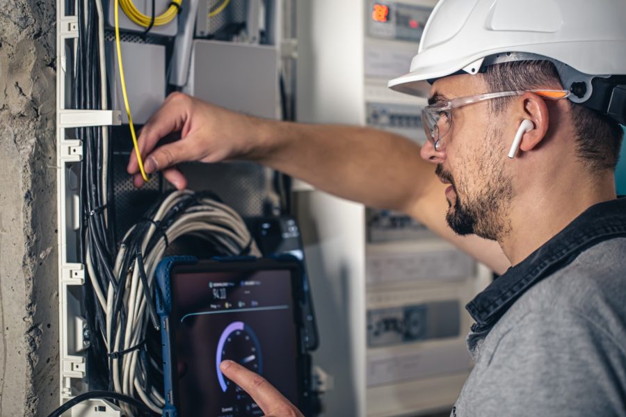 192803548 man an electrical technician working in a switchboard with fuses